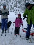 Dona, Zia and Steve putting on skis