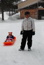 Dona towing Dylan, Mya to the sledding hill